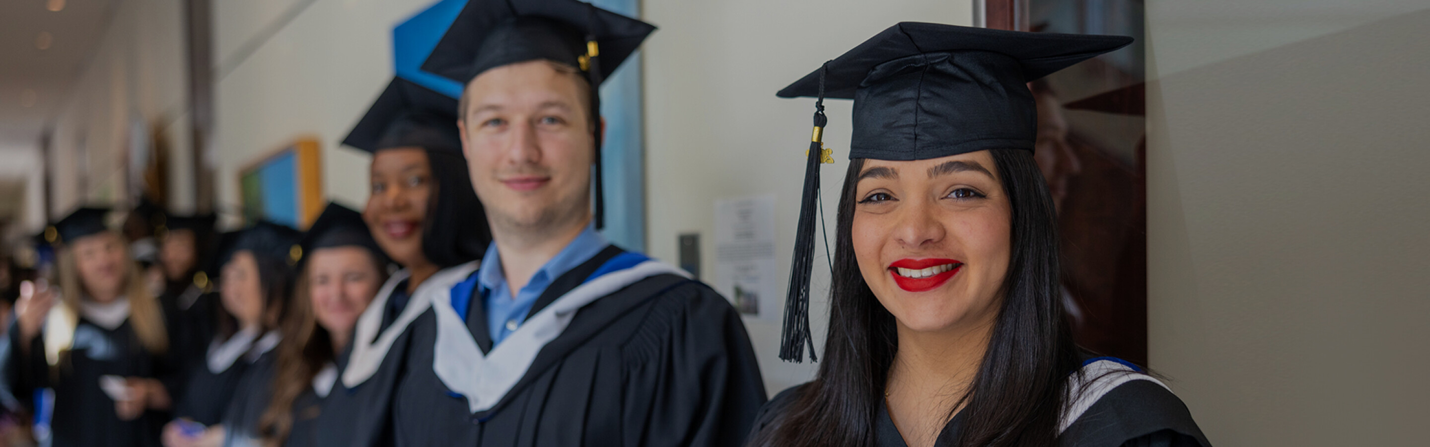 Two graduates standing together in cap and gown