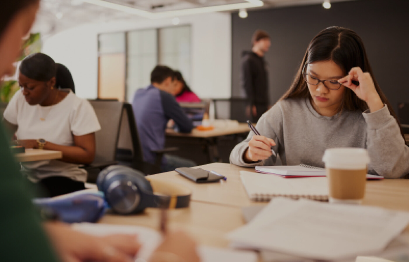 Student working at a table with other students