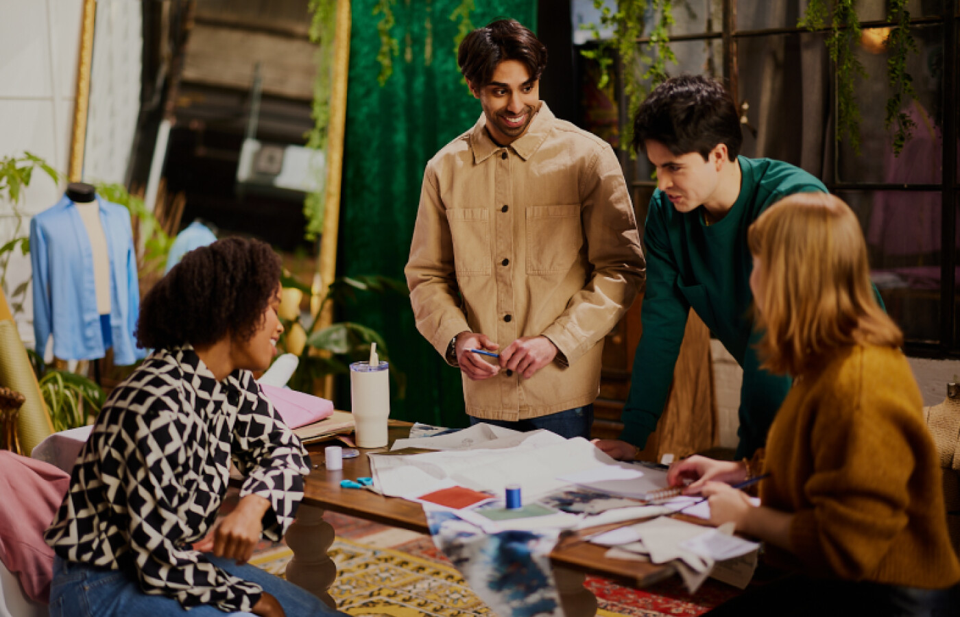 Students standing around a table with designs