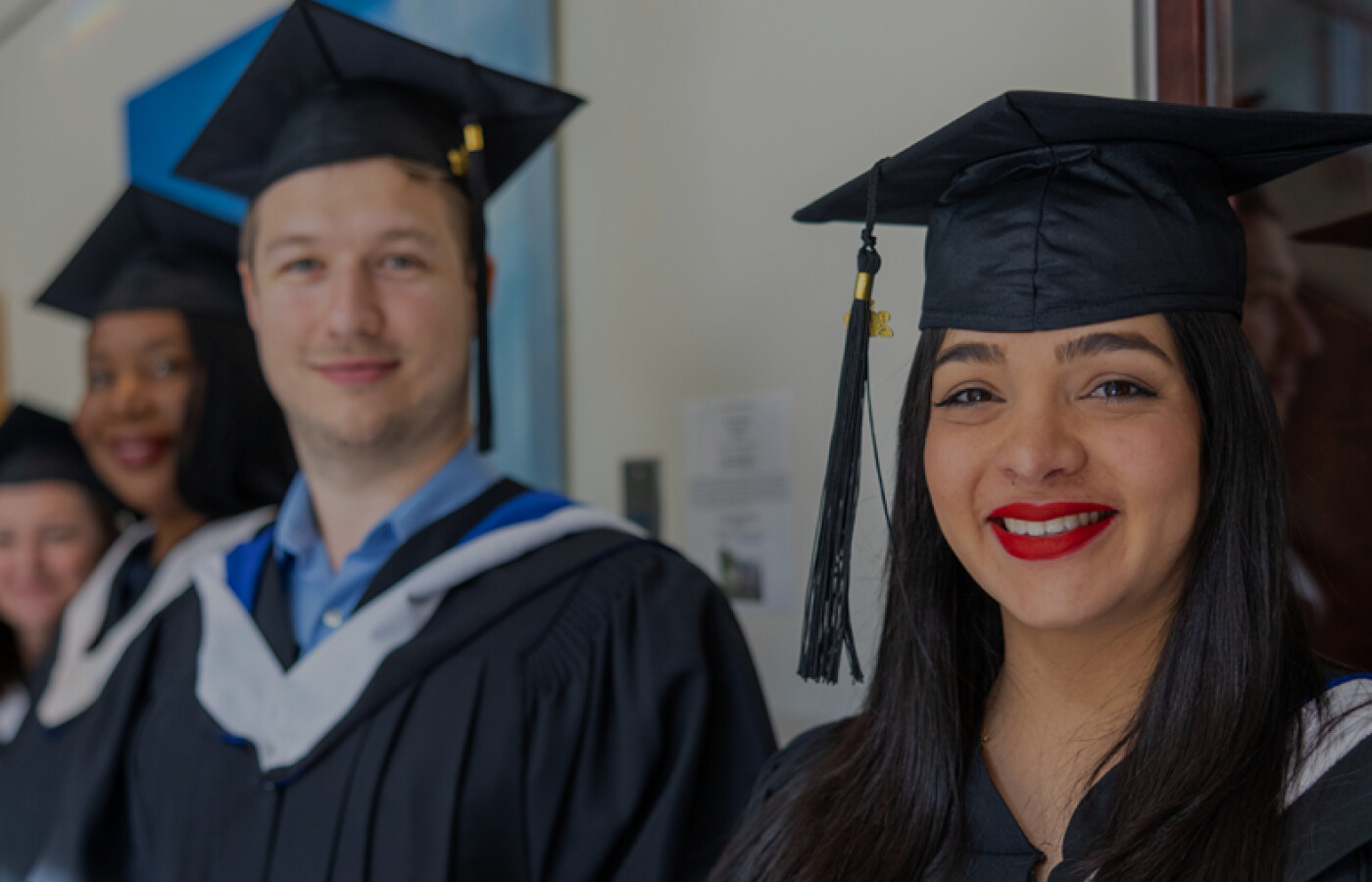 Two graduates standing together in cap and gown